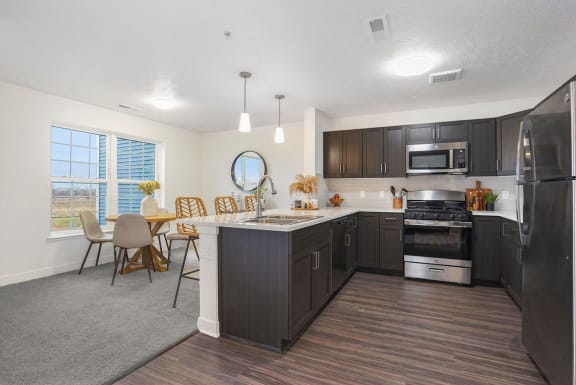 an open kitchen and dining room with a table and chairs at Meadowbrooke Apartment Homes, Grand Rapids, 49512