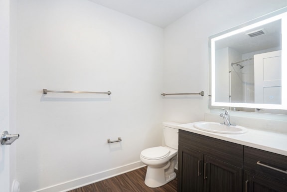 a bathroom with a toilet sink and mirror at Meadowbrooke Apartment Homes, Grand Rapids, Michigan