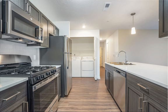 an empty kitchen with stainless steel appliances and wooden floors at Meadowbrooke Apartment Homes, Grand Rapids, 49512