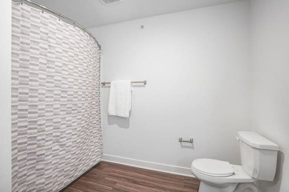 a white bathroom with a toilet and a shower at Meadowbrooke Apartment Homes, Michigan