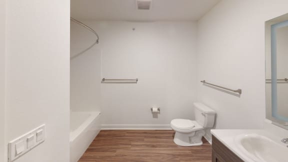 a bathroom with a toilet and a sink and a bath tub at Meadowbrooke Apartment Homes, Grand Rapids, 49512