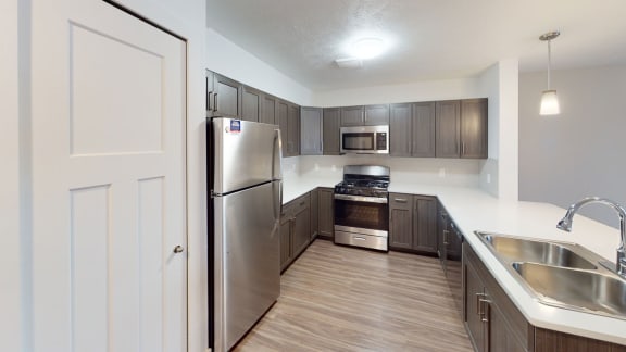 a kitchen with stainless steel appliances and wooden cabinets at Meadowbrooke Apartment Homes, Grand Rapids, 49512