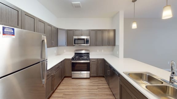 a kitchen with stainless steel appliances and wooden cabinets at Meadowbrooke Apartment Homes, Grand Rapids