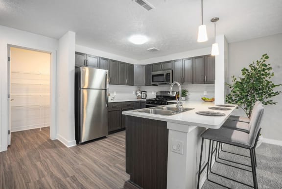 a kitchen with a island and a stainless steel refrigerator at Meadowbrooke Apartment Homes, Grand Rapids