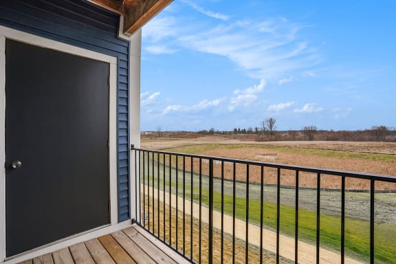 the view from the deck of a home with a door to a field at Meadowbrooke Apartment Homes, Grand Rapids, Michigan