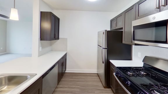 a kitchen with stainless steel appliances and white counter tops at Meadowbrooke Apartment Homes, Grand Rapids