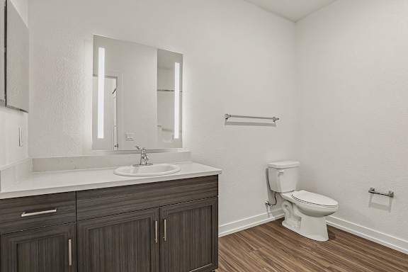 A white bathroom with a toilet and sink at Meadowbrooke Apartment Homes in Grand Rapids, MI 49512