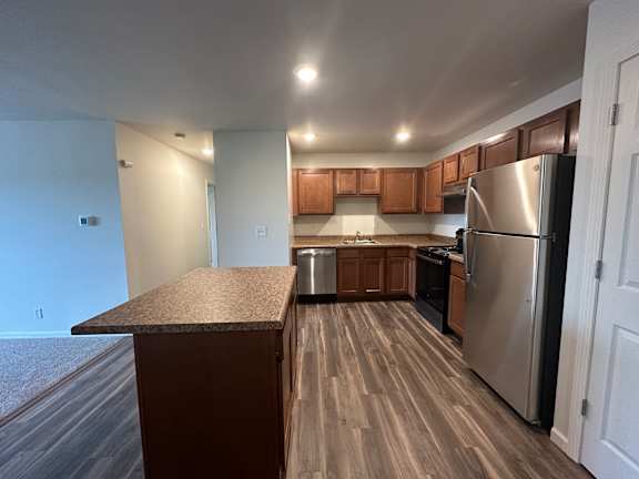 A kitchen with a refrigerator, stove, and oven.