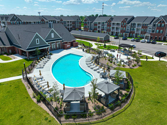 an aerial view of a resort style pool with lounge chairs and umbrellas at Montgomery Place Apartments, Montgomery, IL