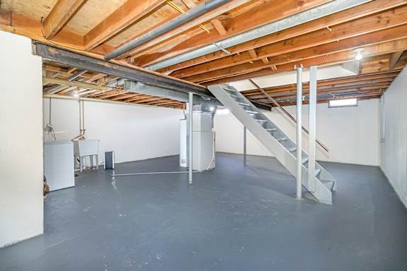 A basement with a washer and dryer and lots of storage space at Mount Royal Townhomes in Kalamazoo, MI