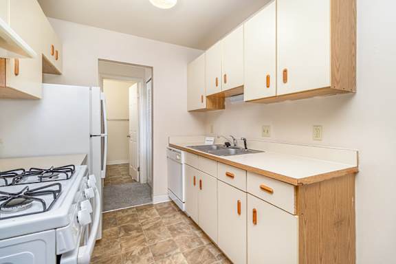 A kitchen with a white gas stove and a dishwasher at Mount Royal Townhomes in Kalamazoo, MI