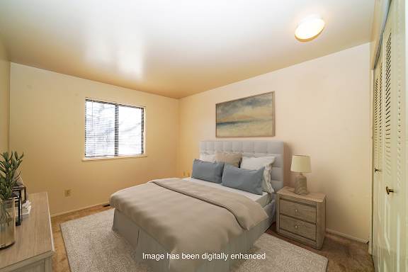 A bedroom with a large bed and a window at Mount Royal Townhomes in Kalamazoo, Michigan