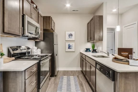 a kitchen with stainless steel appliances and white countertops at Montgomery Place Apartments, Montgomery, Illinois