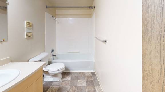 A bathroom with a toilet, sink, and bathtub at Mount Royal Townhomes, Kalamazoo, MI