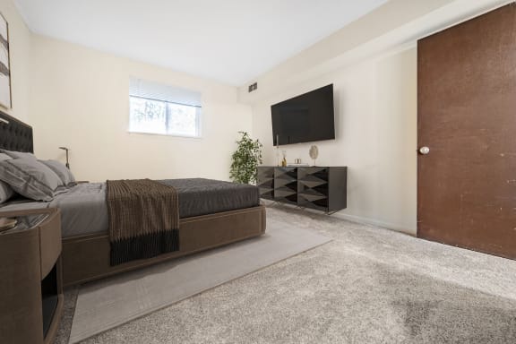 a bedroom with a large bed and a tv on the wall