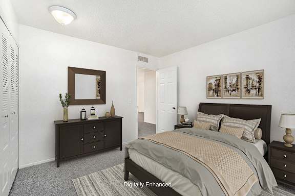 A bedroom with a bed, dresser, and mirror at Newport Village Apartments, Portage, MI