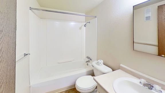 a bathroom with a sink toilet and a bathtub/shower combination a bathroom with a sink toilet and a bathtub/shower combination at Normandy Village Apartments, Michigan City, Indiana