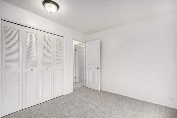 an empty bedroom with white closet doors an empty bedroom with white closet doors at Normandy Village Apartments, Michigan City, IN