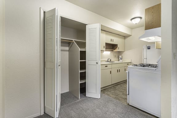 a kitchen with white appliances and a closet a kitchen with white appliances and a closet at Normandy Village Apartments, Michigan City, 46360