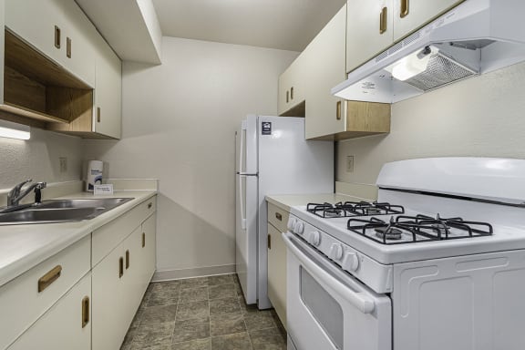 a kitchen with a stove refrigerator and sink a kitchen with a stove refrigerator and sink at Normandy Village Apartments, Michigan City, IN