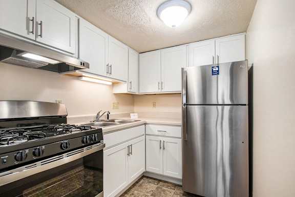 An upgraded kitchen with a stainless steel appliances and white cabinets at Normandy Village Apartments, Michigan City, 46360