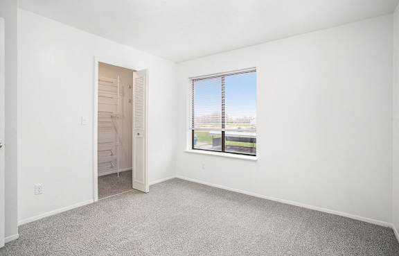A bedroom with a large window and a walk-in closet at North Pointe Apartments, Elkhart, IN, 46514