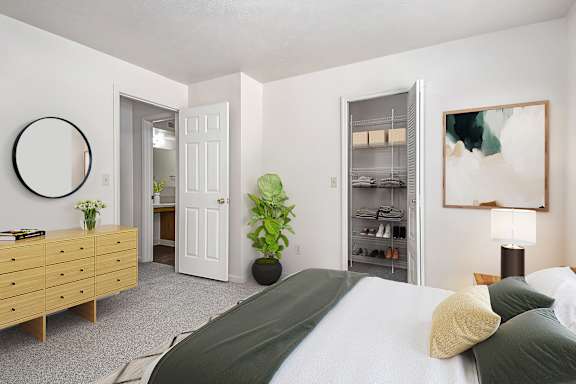 A bedroom with a bed, dresser, and a walk-in closet at North Pointe Apartments, Elkhart, IN, 46514
