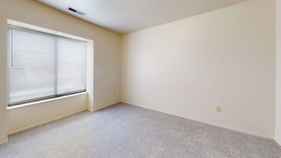 an empty bedroom with a large window and carpeting  at Oak Shores Apartments, Oak Creek, 53154