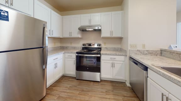 a kitchen with stainless steel appliances and white cabinets  at Oak Shores Apartments, Oak Creek, 53154