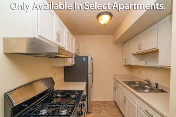Kitchen with Stainless Steel Appliances and Shaker-style Cabinets at Old Farm Apartments in Elkhart, IN