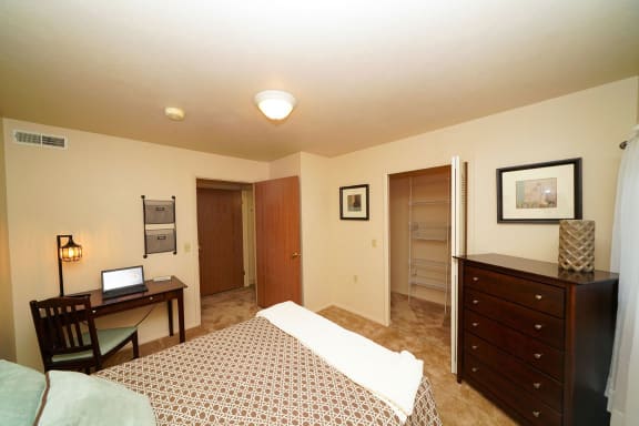 a bedroom with a bed and a desk at Orchard Lakes Apartments, Toledo