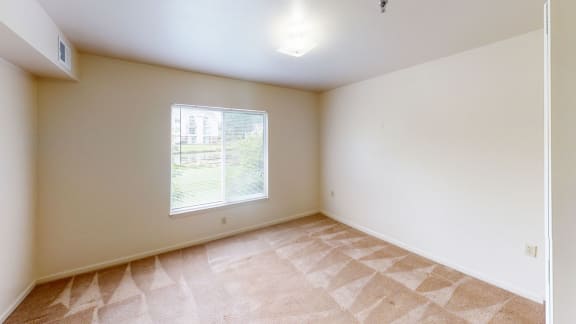 an empty living room with a large window at Orchard Lakes Apartments, Toledo, 43615
