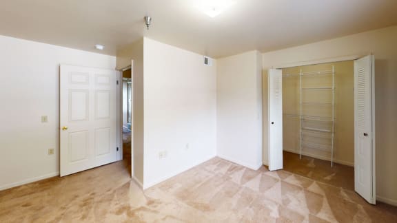 an empty room with a closet and a door to a bathroom at Orchard Lakes Apartments, Toledo, OH