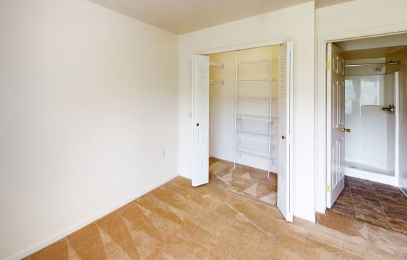 a bedroom with a closet and a mirrored closet door at Orchard Lakes Apartments, Toledo, OH