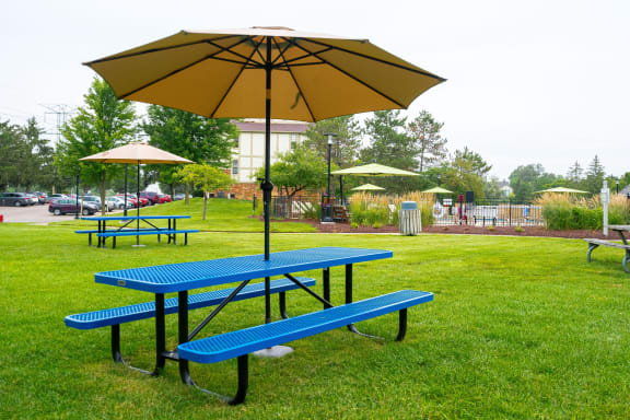 a blue picnic table with an umbrella on top of it at Stone Ridge Apartments, Michigan, 48393