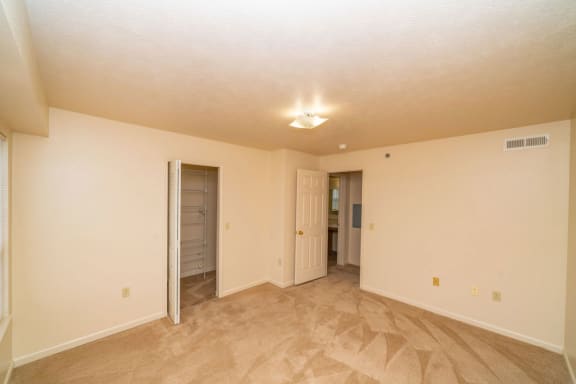 an empty living room with a door to a closet  at Pine Knoll Apartments, Michigan