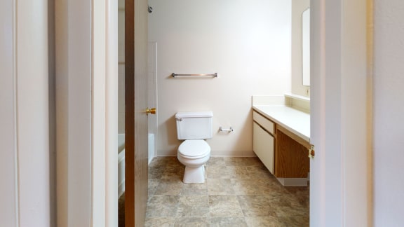 a bathroom with a toilet and a sink  at Pine Knoll Apartments, Battle Creek, 49014