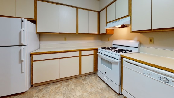 a kitchen with white appliances and white cabinets at Pine Knoll Apartments, Battle Creek, MI, 49014