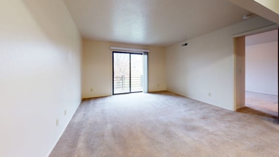an empty living room with a door to a balcony at Pine Knoll Apartments, Michigan, 49014