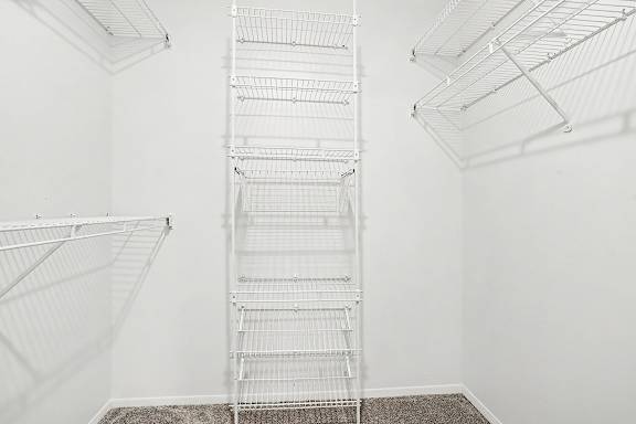 A walk-in closet with white shelves at Pine Knoll Apartments, Battle Creek