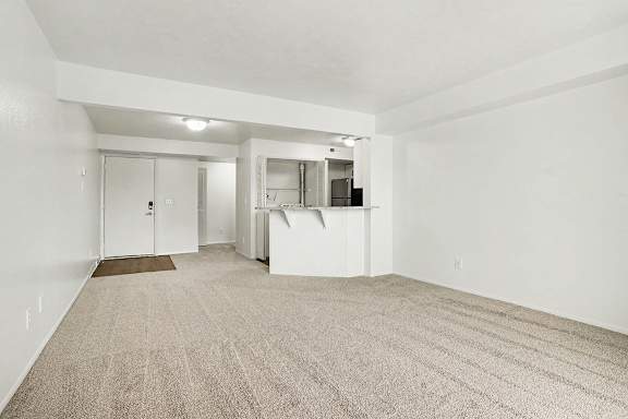 A dining room with a carpeted floor and a breakfast bar at Pine Knoll Apartments, Battle Creek