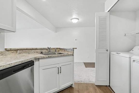 A white laundry area with a washer and dryer at Pine Knoll Apartments, Battle Creek