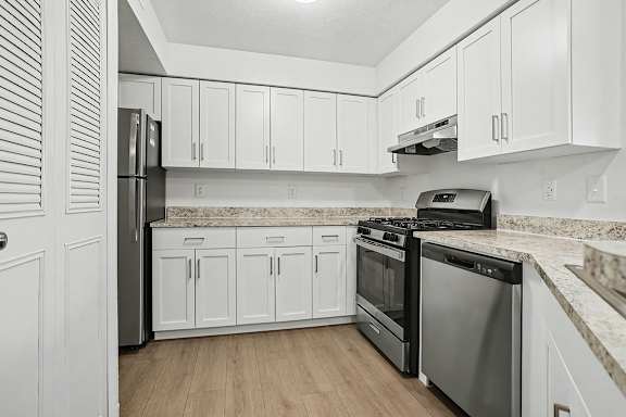 A kitchen with white cabinets and stainless steel appliances at Pine Knoll Apartments, Battle Creek