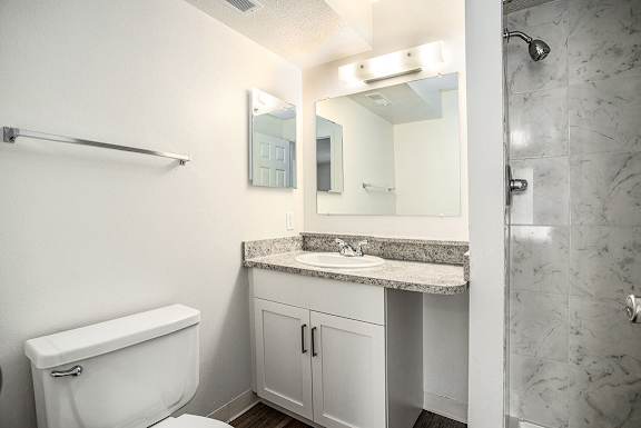 A bathroom with a shower, sink with vanity and a toilet A bathroom with a shower, sink with vanity and a toilet at Pine Knoll Apartments, Battle Creek, 49014