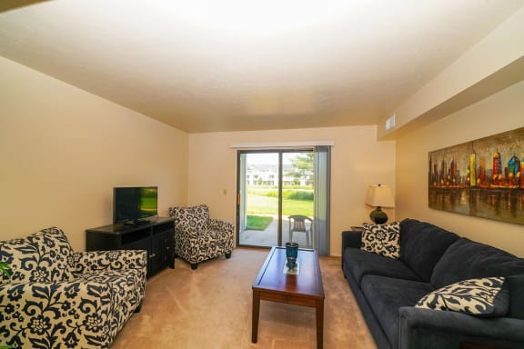 a living room with a couch and a table  at Pine Knoll Apartments, Battle Creek, Michigan