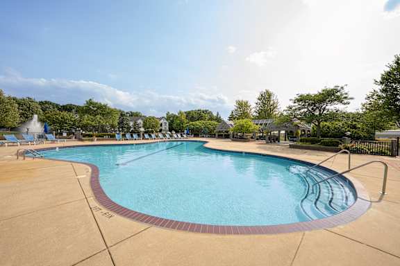 A large outdoor swimming pool with a red border and a blue water surface.