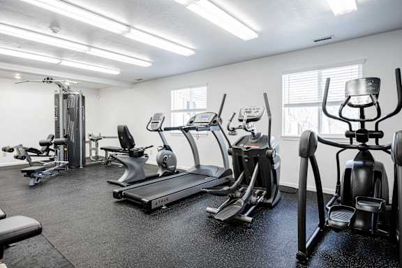 A gym with treadmills, elliptical machines, and other exercise equipment.