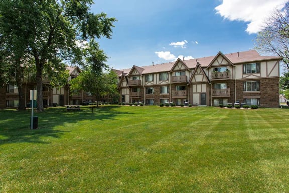 our apartments showcase an open, grassy courtyard with picnic tables  at Polo Run Apartments, Greenwood, Indiana