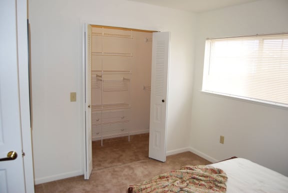 a bedroom with a closet and a bed  at Hunters Pond Apartment Homes, Champaign, IL, 61820
