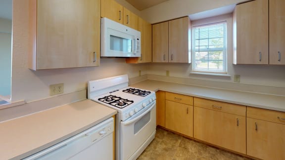 a kitchen with white appliances and wooden cabinets  at Hunters Pond Apartment Homes, Champaign, Illinois